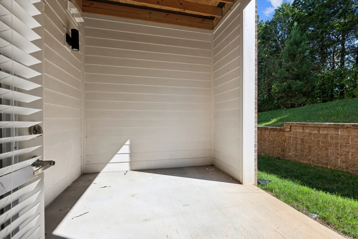 A light-filled open space with a doorway, natural light streaming through, and an inviting setup that suggests potential for a personalized workspace or hobby area. The space feels flexible and bright, ideal for productive activities.