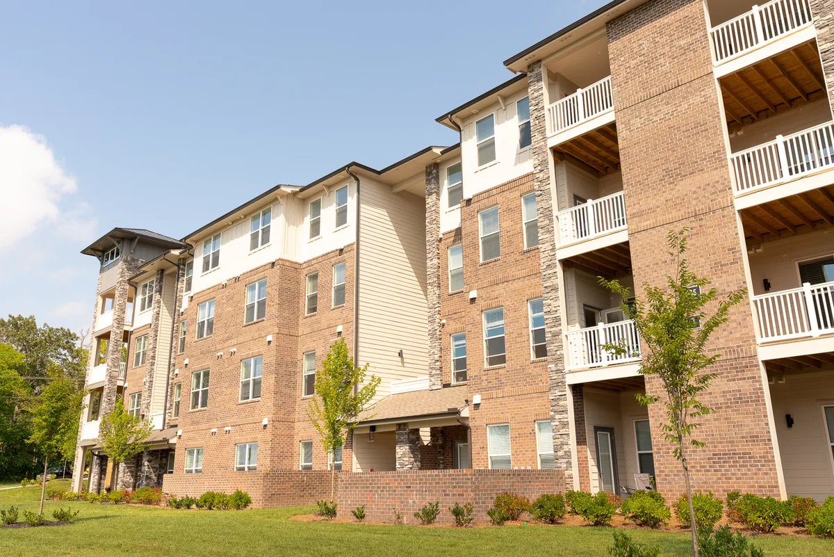 This exterior shot showcases the modern brick architecture of the Overlook at Farragut, complete with balconies and lush green landscaping. The inviting outdoor space hints at the property's proximity to major business centers while highlighting the attractive and professional appearance of the community.